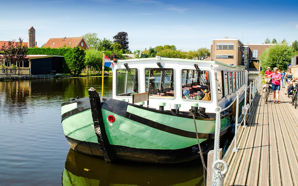Tourist boat docked for canal tour in Kinderdijk, Netherlands.