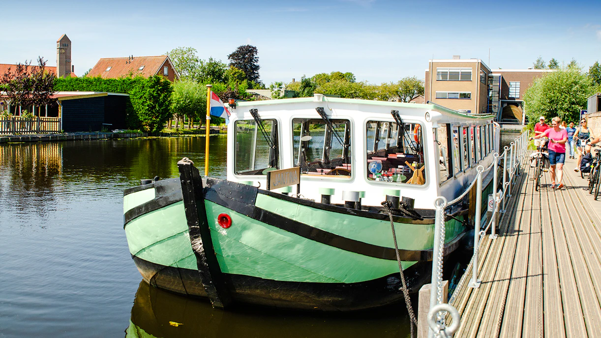 Tourist boat docked for canal tour in Kinderdijk, Netherlands.