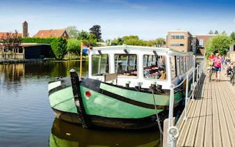 Tourist boat docked for canal tour in Kinderdijk, Netherlands.