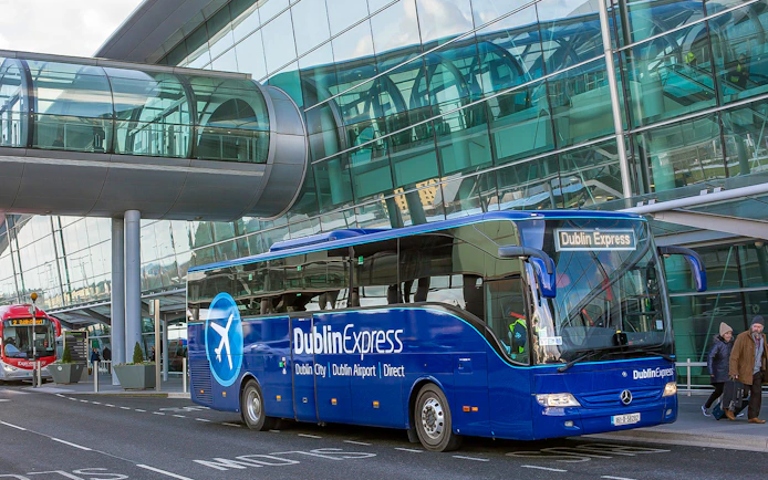 Dublin Express bus at Dublin Airport terminal entrance.