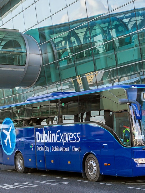 Dublin Express bus at Dublin Airport terminal, offering round-trip service to Custom House Quay.