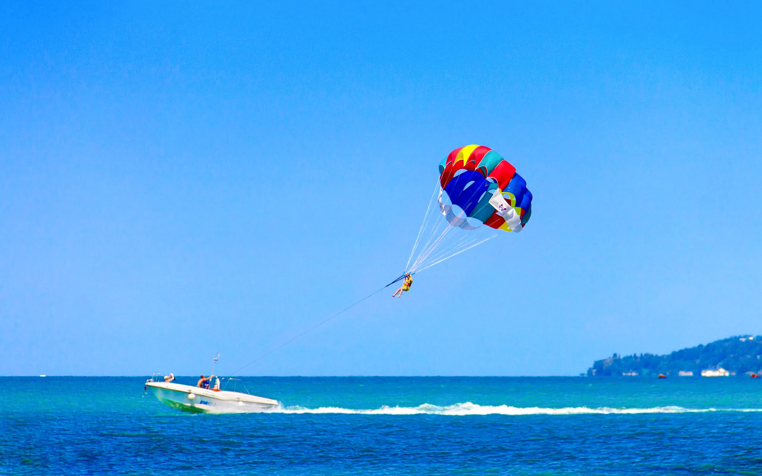 Parasailing over the ocean at Saona Island with a colorful parachute.