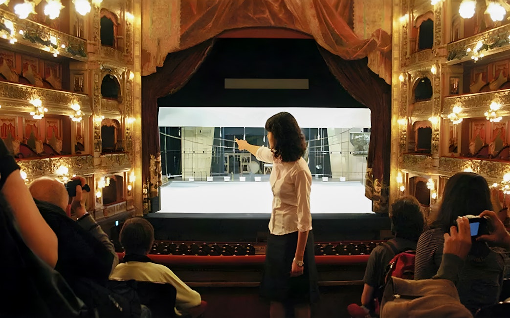Tourist group with guide inside Teatro Colón, Buenos Aires, viewing stage.