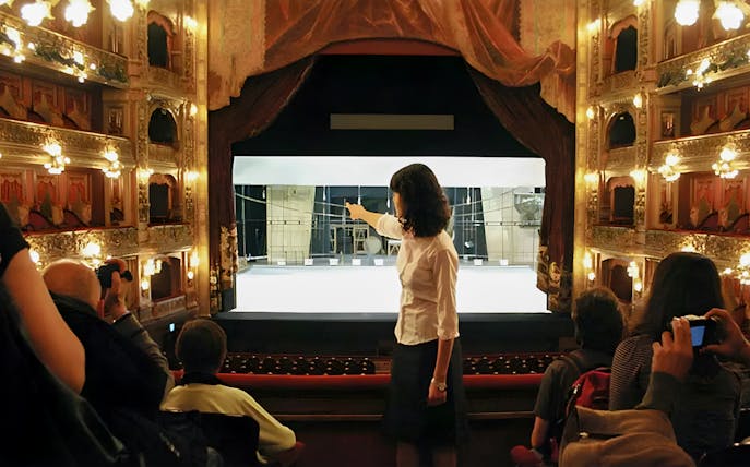 Tourist group with guide inside Teatro Colón, Buenos Aires, viewing stage.