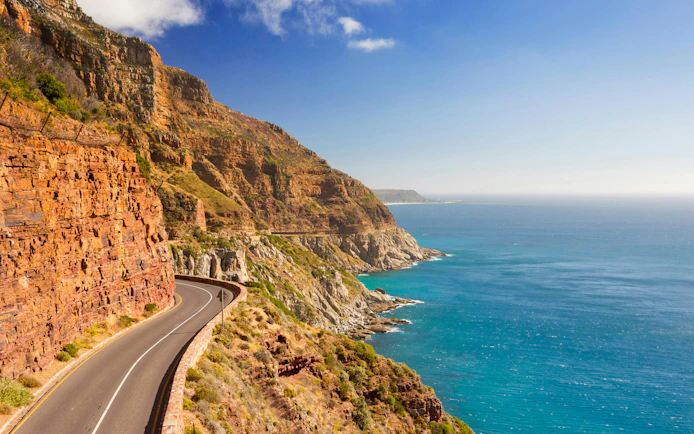 Chapman's Peak Drive winding along cliffs near Cape Town, South Africa, with ocean view.