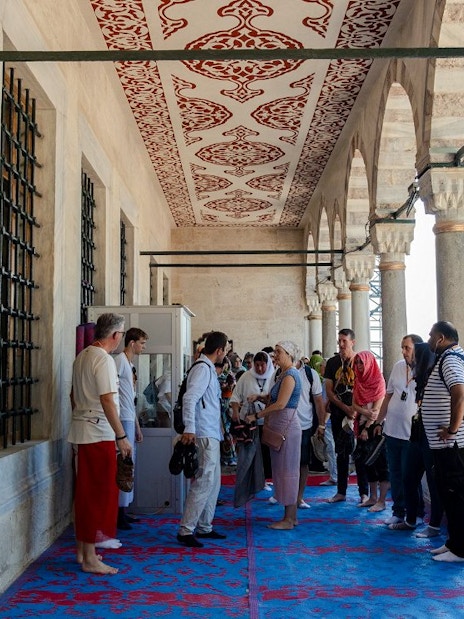 Visitors on a guided tour at Hagia Sophia, Istanbul, standing on a decorated balcony.