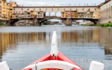 Gondola approaching Ponte Vecchio on a guided boat tour in Florence.