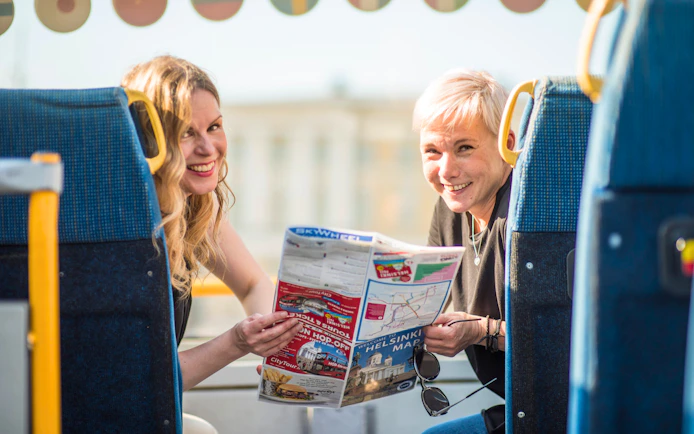 Guests reading a map aboard a hop on hop off bus in Helsinki.