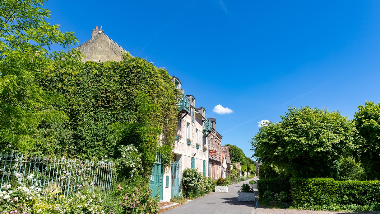 Giverny garden path with vibrant flowers and Monet's house, Paris to Giverny Tours.