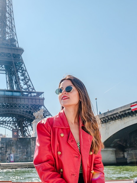Lady enjoying the Official Emily in Paris Champagne Seine Cruise with Eiffel Tower in background.