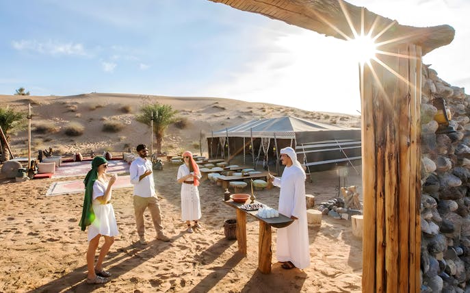 Guests enjoying a desert camp with traditional refreshments during a heritage safari experience.