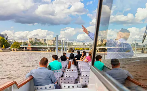Passengers enjoying a brunch cruise on the River Thames with views of London bridges.