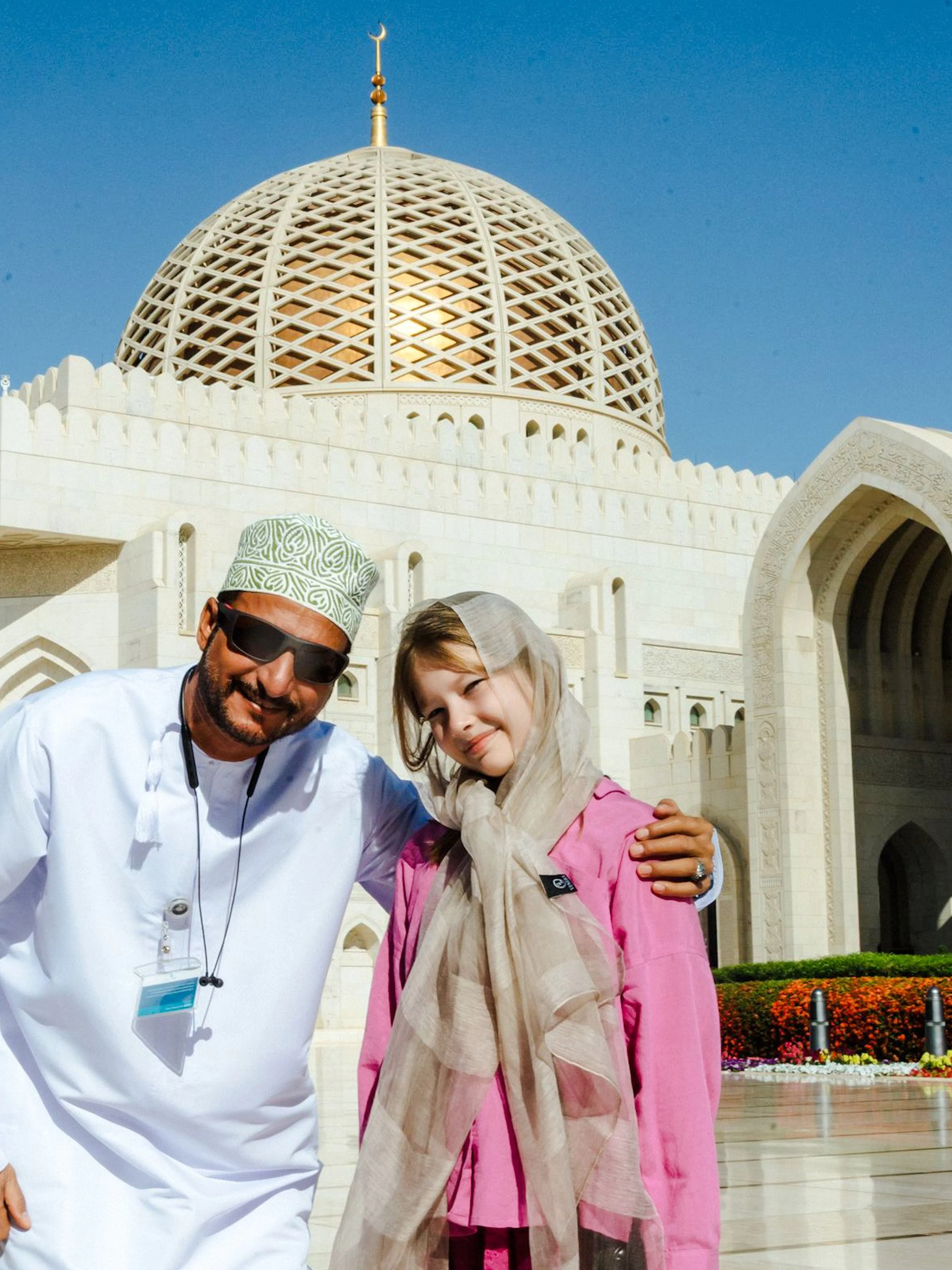 Guide with tourists at Sultan Qaboos Grand Mosque, Oman.