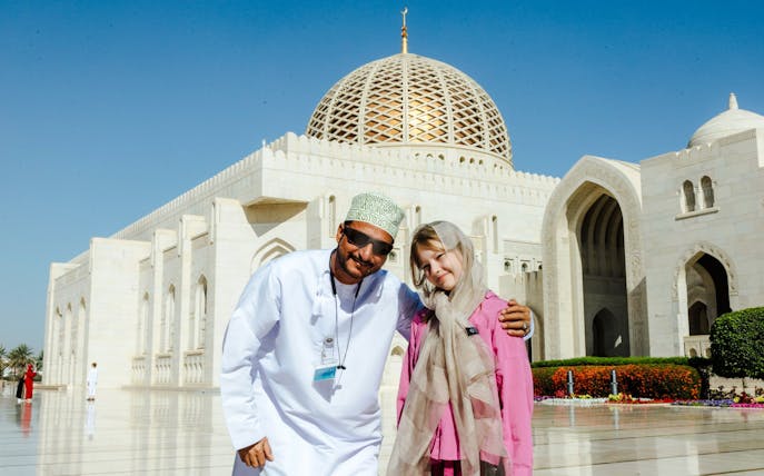 Guide with tourists at Sultan Qaboos Grand Mosque, Oman.