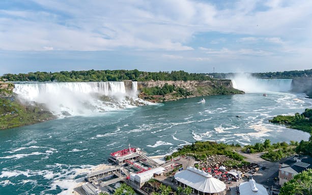 Aerial view of Horseshoe Falls at Niagara with tour boats and observation deck.