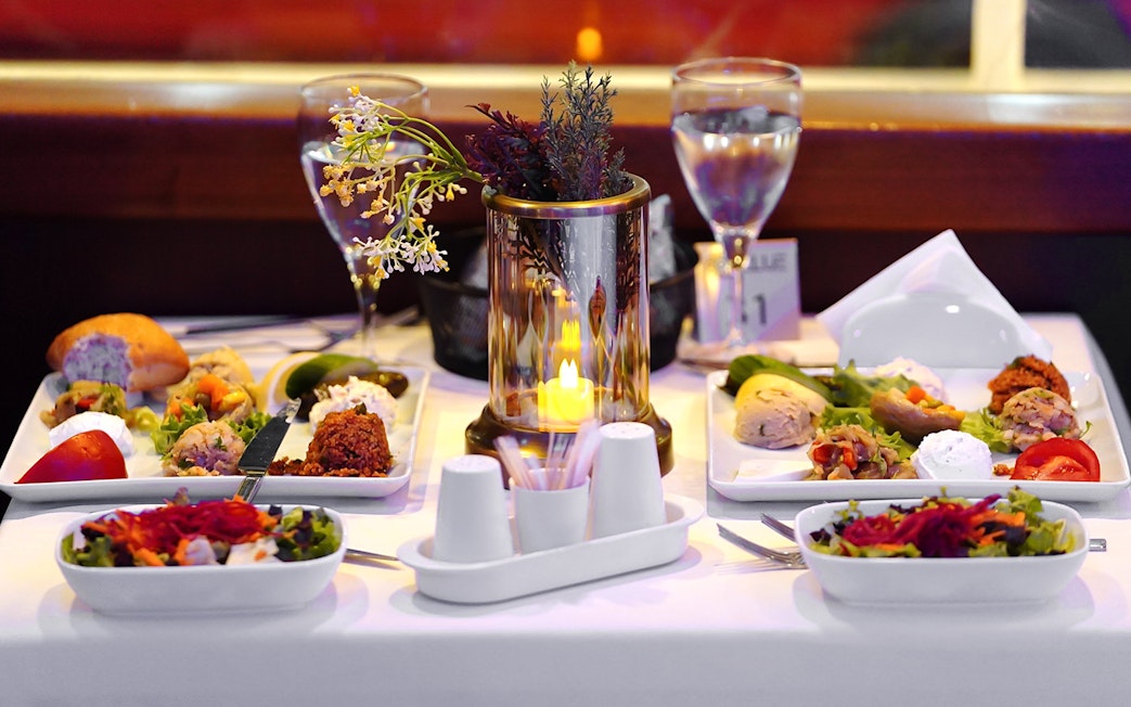 Turkish dinner spread on a table with candlelight during Bosphorus Dinner Cruise.