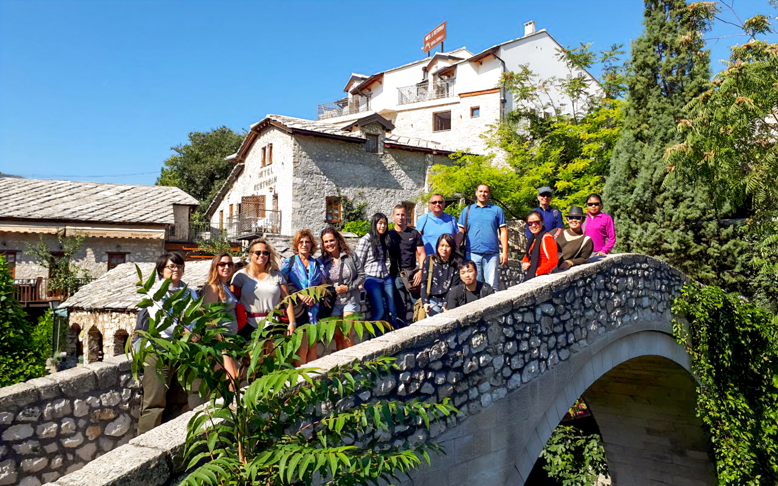 Tourists exploring Kriva ćuprija bridge in Mostar
