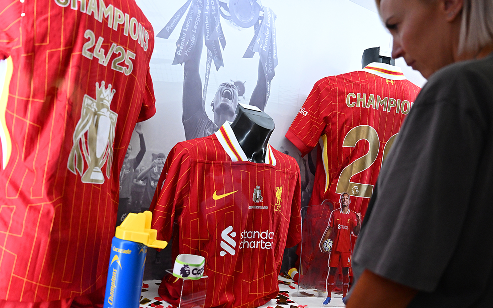 Liverpool FC jerseys displayed at Anfield museum exhibit.