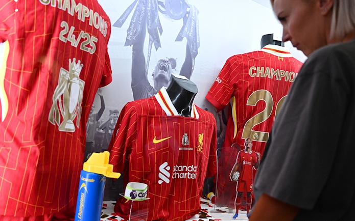 Liverpool FC jerseys displayed at Anfield museum exhibit.
