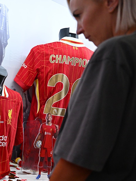 Liverpool FC jerseys displayed at Anfield museum exhibit.