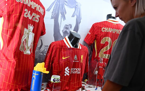 Liverpool FC jerseys displayed at Anfield museum exhibit.