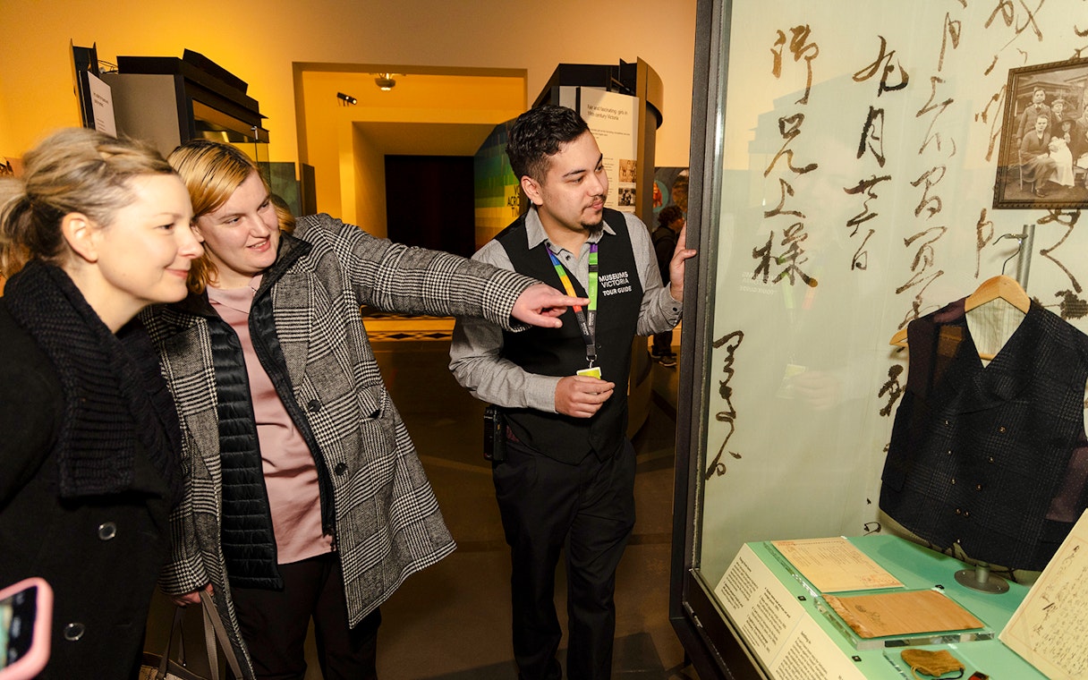 Tour guide showing visitors an exhibit at the Immigration Museum.