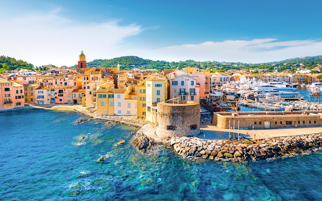 Saint-Tropez harbor with colorful buildings and yachts along the waterfront.