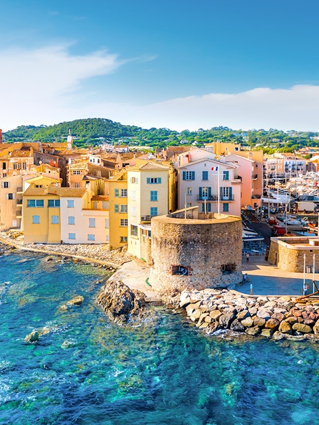 Saint-Tropez harbor with colorful buildings and yachts along the waterfront.