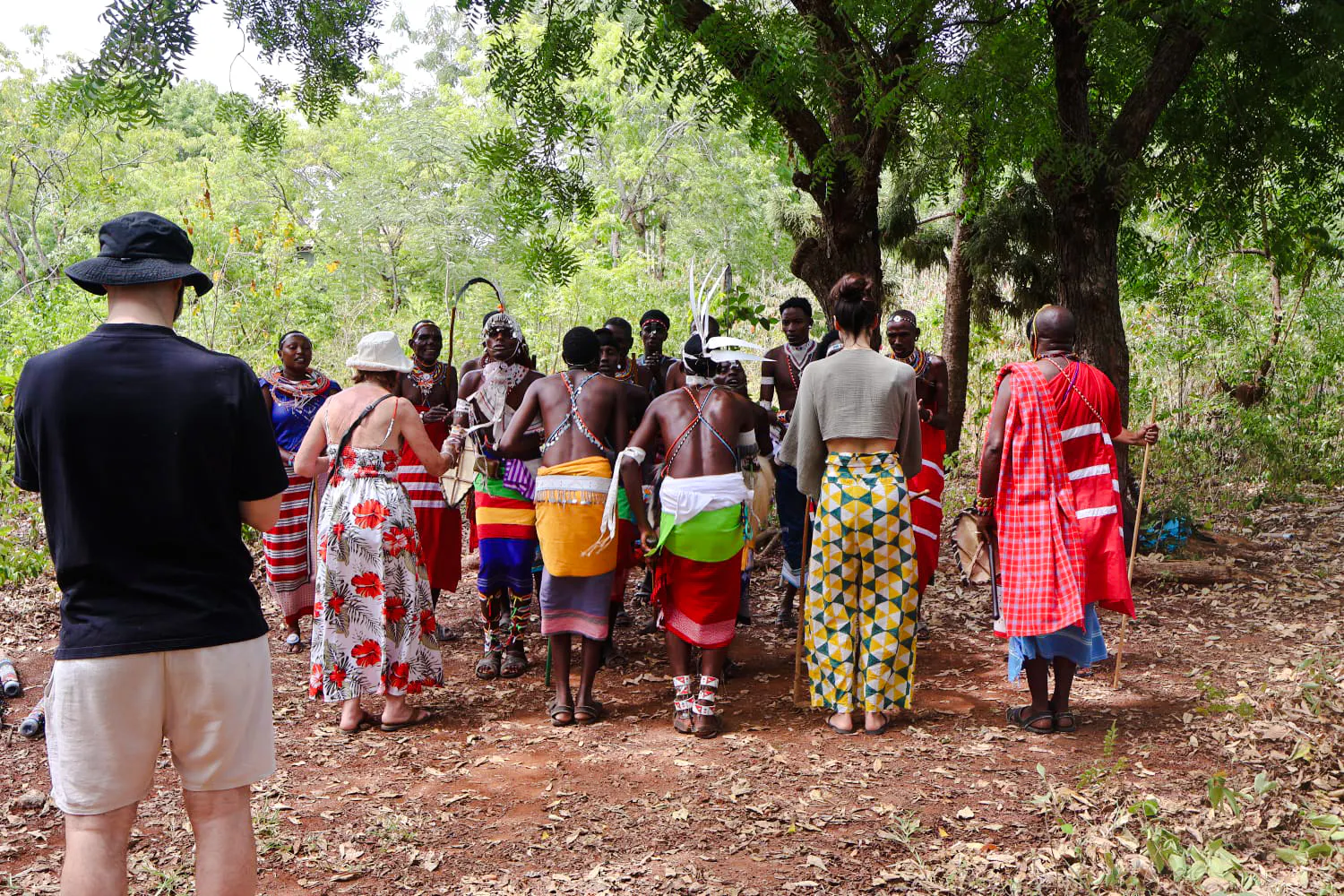Maasai group performing cultural dance under trees at Diani Beach.