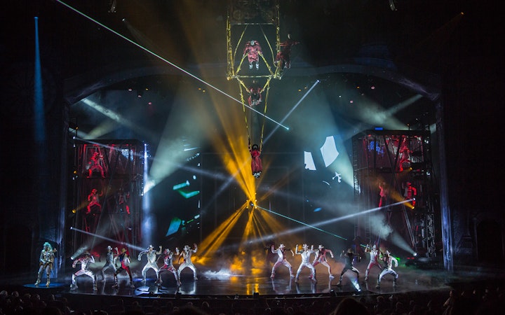 Performers on stage with vibrant lights at Michael Jackson ONE show.