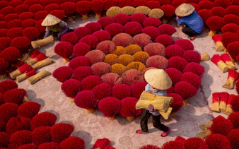Workers arranging incense sticks in a Hanoi village, part of the Hanoi City Tour.