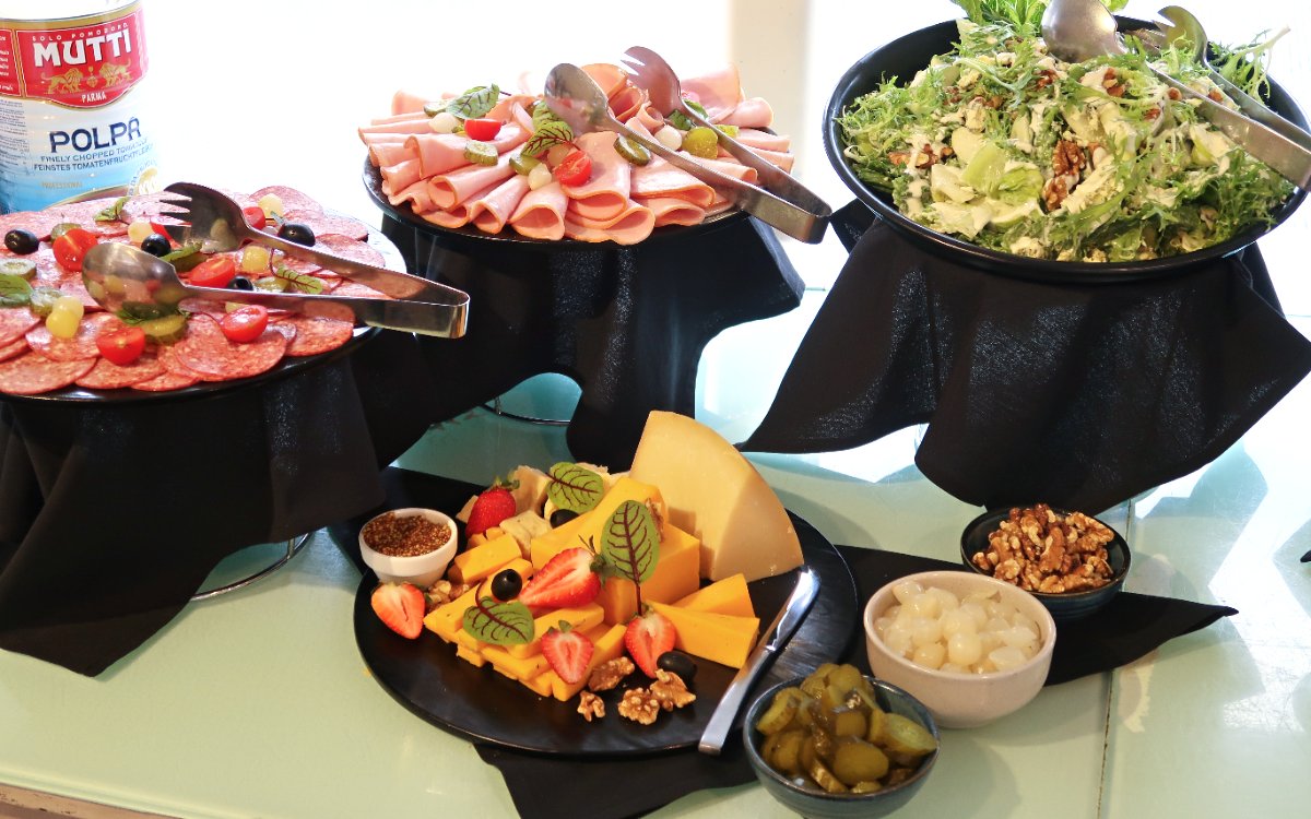 Luxury catamaran buffet with meats, cheeses, salads, and condiments, Sydney cruise.