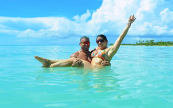 Couple enjoying the clear waters on Saona Island during a Punta Cana catamaran tour.