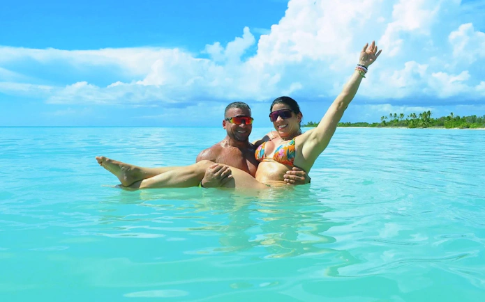 Couple enjoying the clear waters on Saona Island during a Punta Cana catamaran tour.