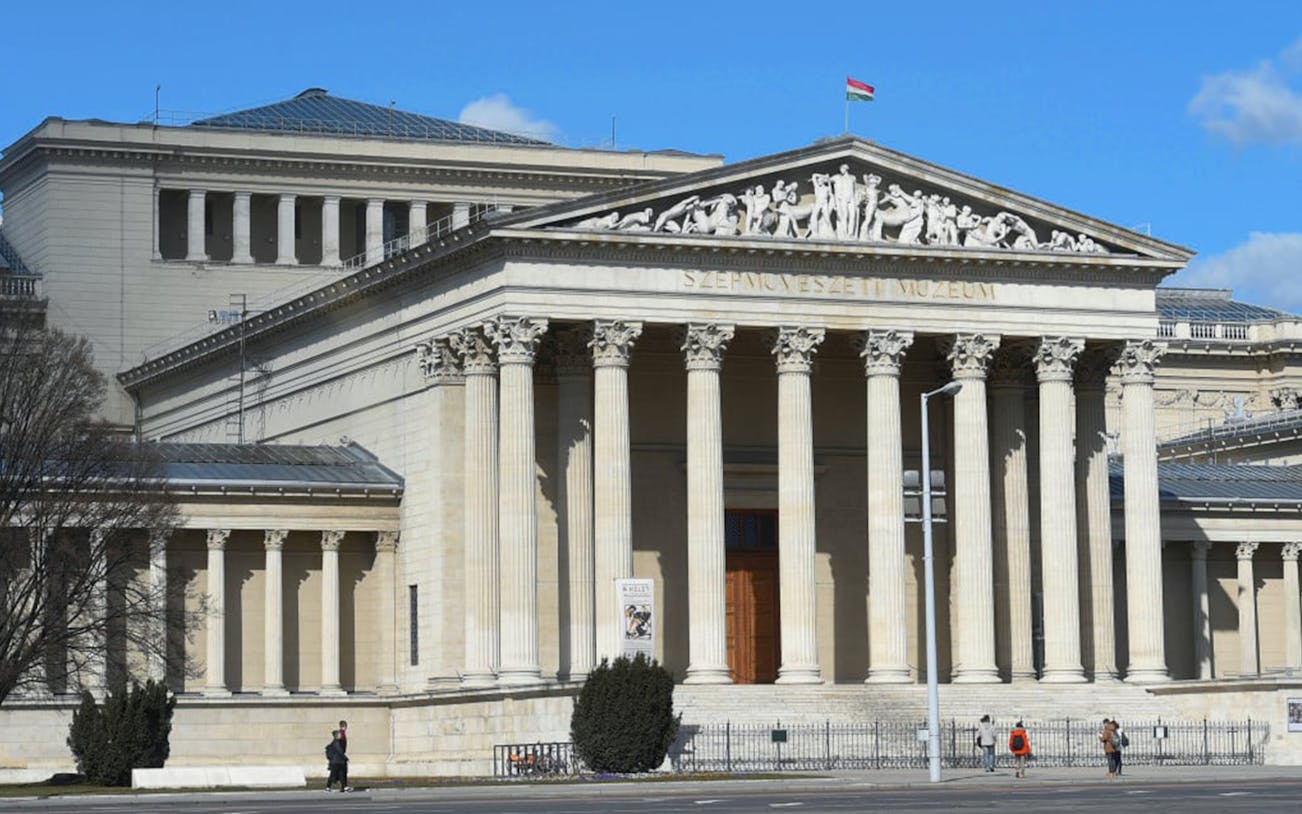 Museum of Fine Arts in Budapest with neoclassical columns and Hungarian flag.