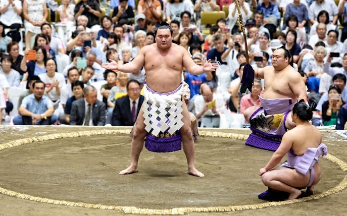 Sumo wrestlers in a ring during the Tokyo Grand Sumo Tournament.
