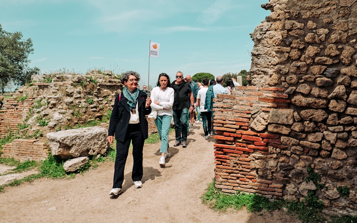 Visitors exploring Paestum Archaeological Site on a guided tour, Italy.