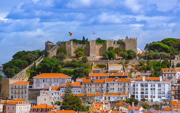 St. George’s Castle overlooking Lisbon with red-roofed buildings below.