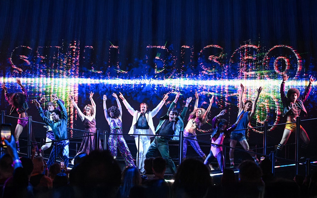 Performers dancing energetically on stage at a DiscoShow event.