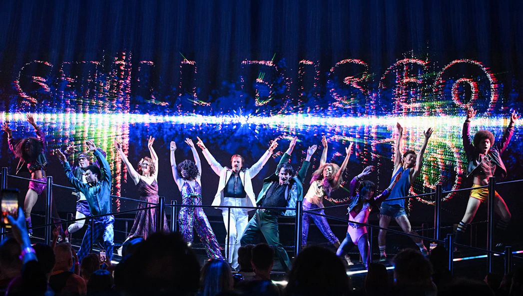 Performers dancing energetically on stage at a DiscoShow event.