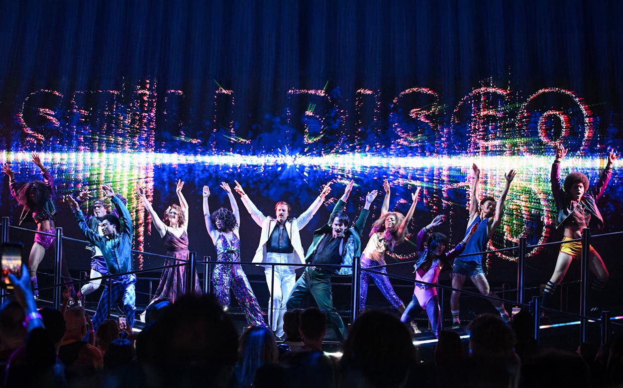 Performers dancing energetically on stage at a DiscoShow event.