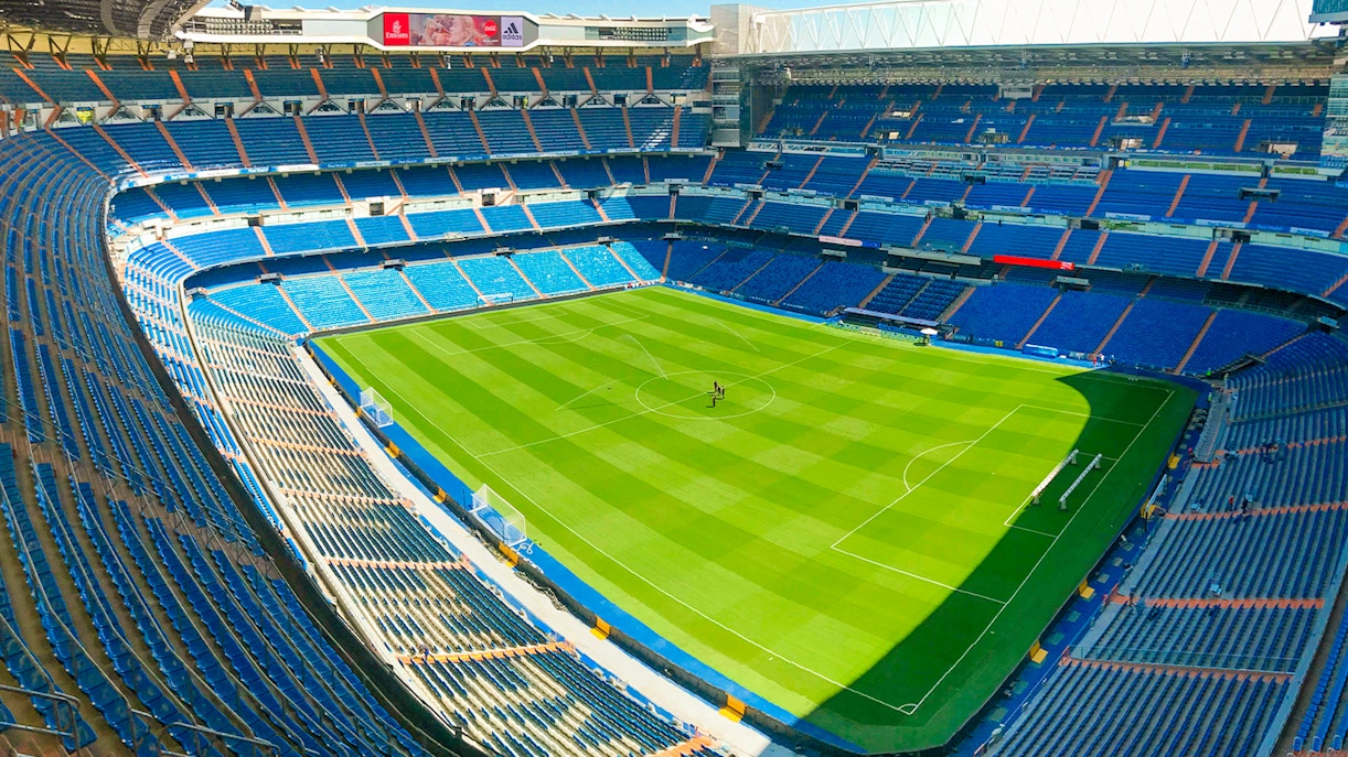 Santiago Bernabeu stadium view from stands, Madrid, showcasing football field and seating areas.