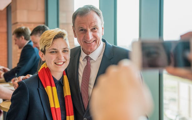 Liverpool FC Legends Q&A attendee posing with a former player during the stadium tour.