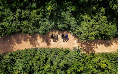 ATVs on a dirt path surrounded by dense greenery in Cancun Extreme Adventuring Park.