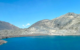 Cajón del Maipo's Embalse del Yeso reservoir with clear blue water and mountainous backdrop in Santiago.