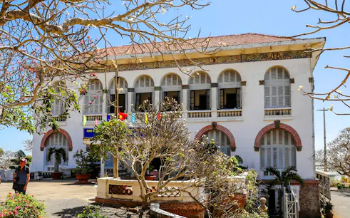 Colonial building with arched windows in Vung Tau, Vietnam, part of city tour from Saigon.