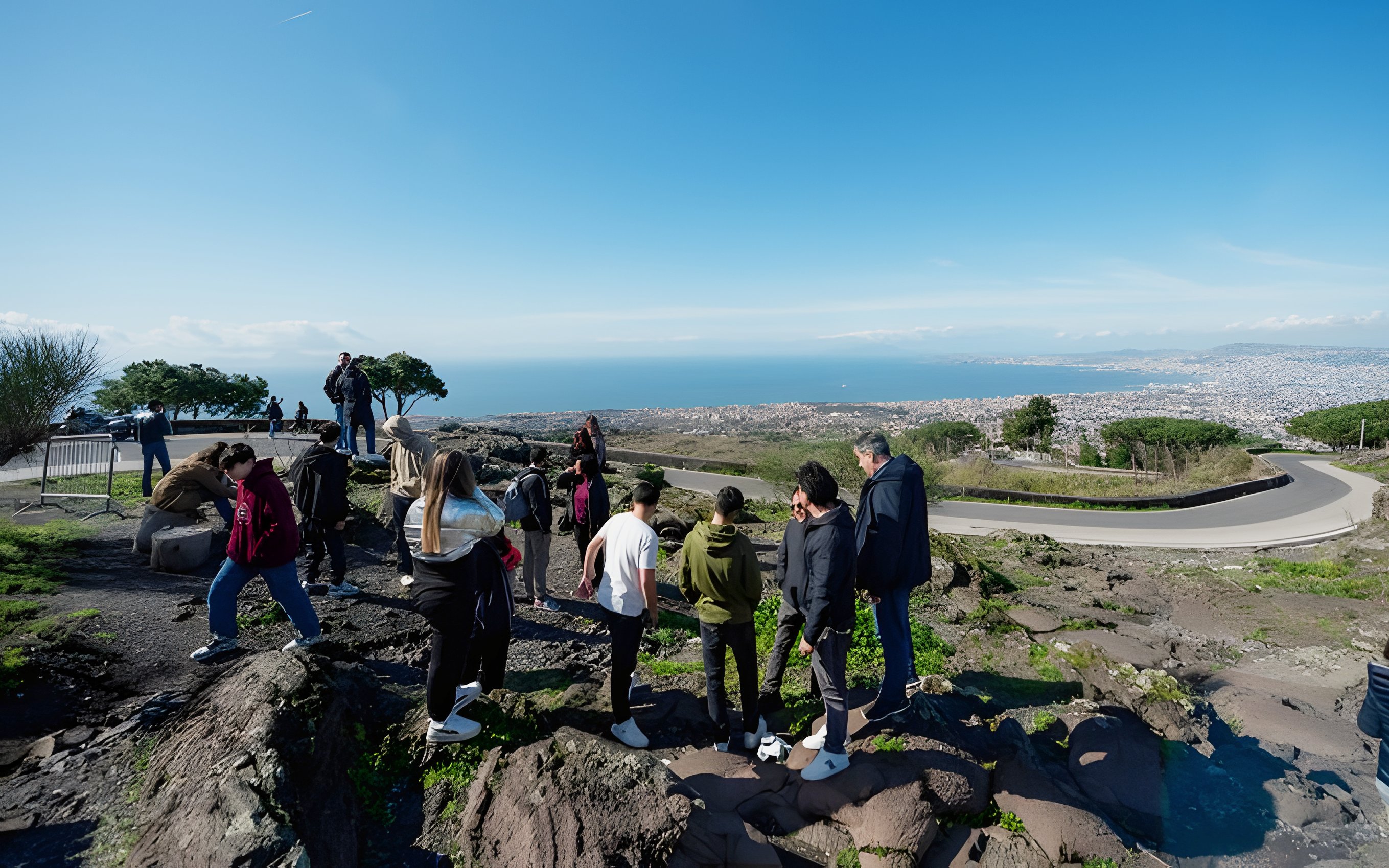 Group hiking at Vesuvius National Park with view of Naples, Italy in the background.