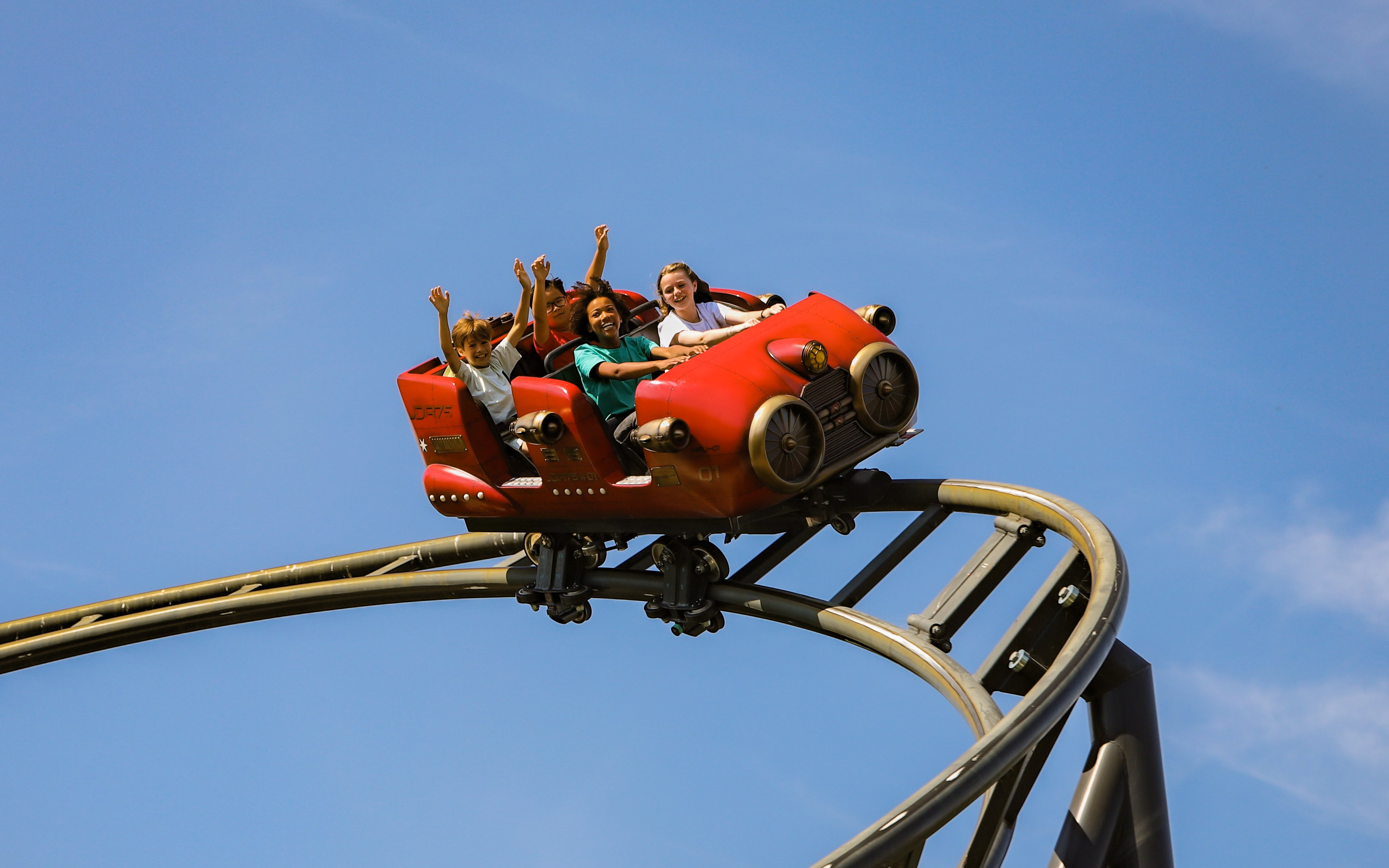 Roller coaster ride at Le Jardin d'Acclimatation, Paris with excited passengers.
