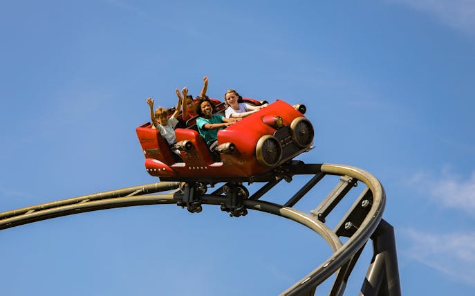 Roller coaster ride at Le Jardin d'Acclimatation, Paris with excited passengers.