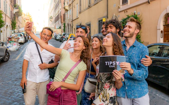 Group taking a selfie on a Rome guided tour in a cobblestone street.